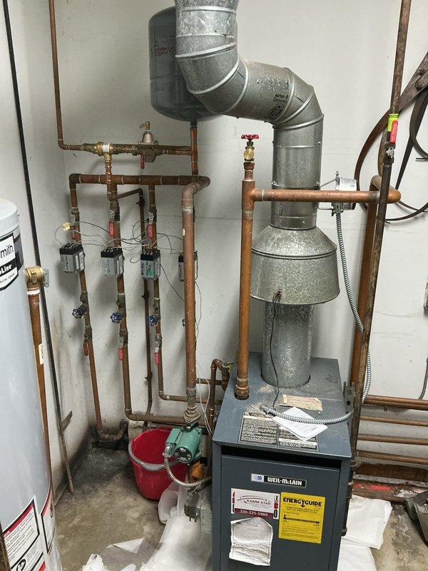 Responded to service call for water heater leaking from bottom in utility closet. Upon arrival, inspected A.O. Smith tanked water heater and confirmed active leak originating from base of unit. Evaluated tank condition and determined internal tank failure causing water discharge onto concrete floor. Documented existing installation including copper supply lines, expansion tank, and flue venting system. Due to compromised tank integrity and safety concerns, recommended immediate replacement of failed water heater unit. Coordinated with property manager for approval and scheduling of replacement installation.