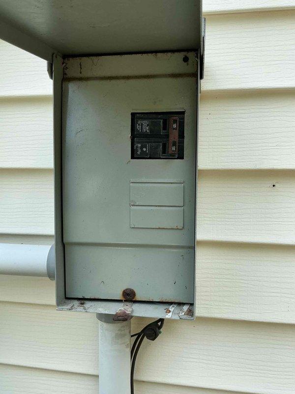 Conducted comprehensive site evaluation for whole-house generator installation. Assessed existing electrical service panel, documented current breaker configuration, and identified weathered outdoor panel with rust deterioration requiring consideration during integration. Photographed electrical infrastructure to determine proper sizing, transfer switch placement, and necessary upgrades to accommodate automatic standby generator system.