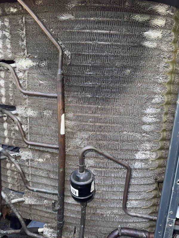 Completed comprehensive tune-up on 10-year-old air conditioning system. Performed full system inspection including evaporator coil examination, blower wheel assessment, and refrigerant line connections verification. Documented system components with photographic evidence showing clean evaporator coil with serpentine fins, properly functioning centrifugal blower assembly, and filter drier installation with secure copper line connections, confirming all components operating within normal parameters.