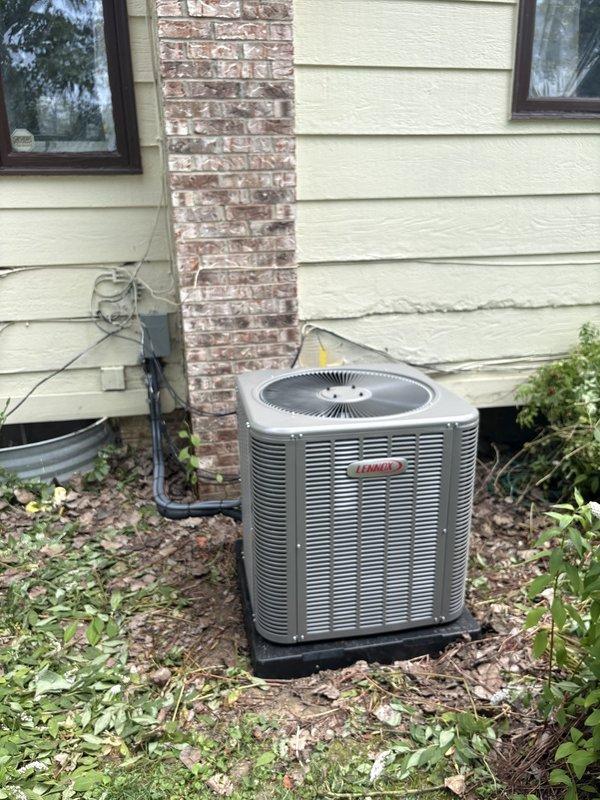 Completed full HVAC system installation including an 80% efficiency Lennox furnace in the basement mechanical room and matching Lennox air conditioning condenser unit on exterior pad. The furnace installation features proper flexible ductwork connections to the existing ventilation system, metal plenum integration for air distribution, and appropriate gas piping and electrical conduit runs. The outdoor condensing unit was positioned on a level platform pad against the home's exterior with proper clearances from the structure, connected via refrigerant lines and electrical service to complete the split system configuration.