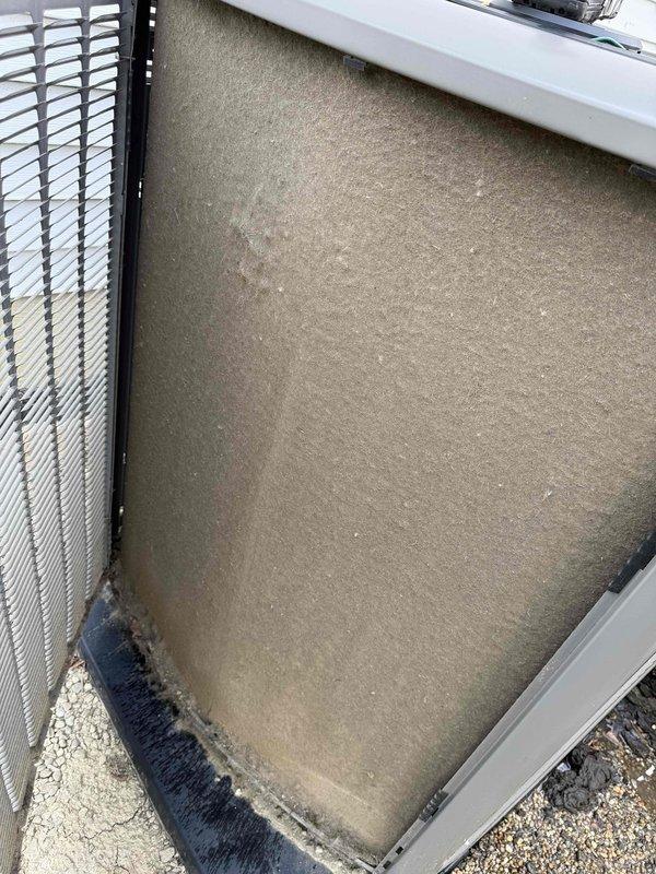 # HVAC Service Report

Responded to no-cooling complaint on 5-year-old residential AC system affecting entire home. Upon inspection, found exterior condensing unit filter and condenser coil heavily contaminated with dirt, dust, and debris buildup, significantly restricting airflow and reducing system efficiency. Removed and cleaned exterior filter, which showed substantial dust accumulation and discoloration from extended use without maintenance. Thoroughly cleaned condenser coil fins, removing thick layers of accumulated particulate matter that had embedded between the horizontal fins, particularly concentrated on the left and center portions of the coil. Heavy contamination was preventing proper heat exchange and causing system to fail cooling. After cleaning both components, verified adequate airflow through condenser unit and confirmed system restored to normal cooling operation. Documented condition with photos showing before-cleaning state of filter and coil. Advised homeowner on