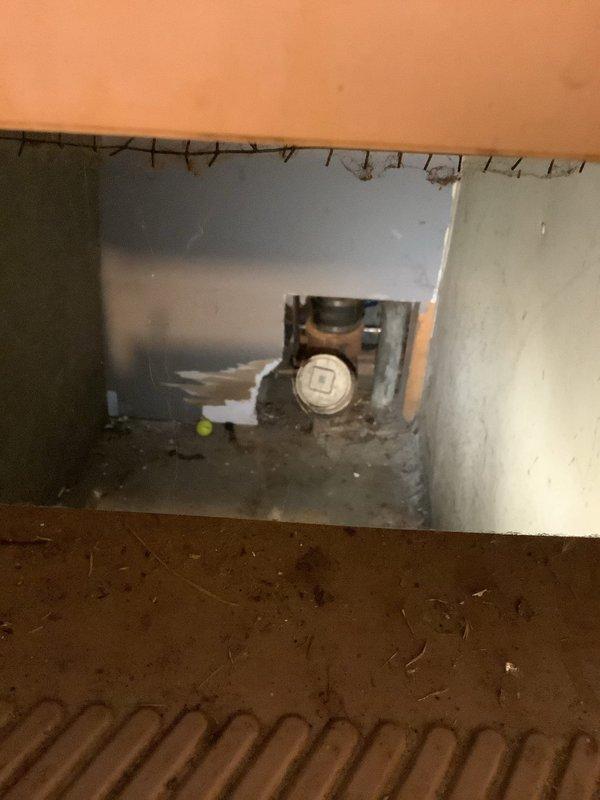 Responded to service call for water leak investigation under kitchen sink and in kitchen area. Upon arrival, conducted thorough inspection of plumbing system including crawl space access and basement drain lines. Identified compromised ceramic main drain line in basement with visible cracking and tree root intrusion. Accessed underfloor area through floor opening to assess extent of water damage and locate source of leak. Documented conditions with photographic evidence showing crawl space access point, exposed plumbing components, and affected areas. Inspected bathroom facilities revealing ongoing renovation work with exposed wall framing and removed drywall sections. Evaluated overall plumbing infrastructure to determine scope of necessary repairs. Provided second opinion assessment as requested, identifying primary issues as failed ceramic drain line requiring replacement due to structural compromise from root penetration and age-related deterioration. Recommended immediate attentio