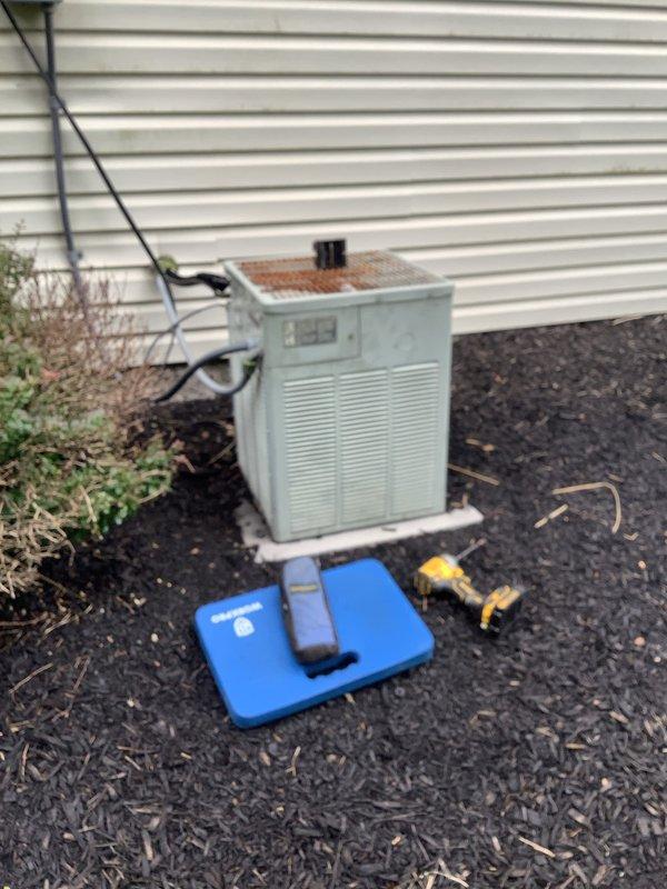 Responded to no cooling complaint on 20-year-old air conditioning system. Found outdoor condenser unit attempting to start but failing to run, with fan motor running excessively hot. Upon inspection, identified failed condenser fan motor and heavily corroded top grill assembly with significant rust damage affecting unit operation. Diagnosed electrical issue preventing compressor from engaging properly while fan motor was overheating due to mechanical failure.