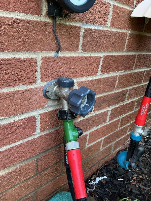 Responded to service call for leaking outdoor spigot. Upon arrival, inspected exterior hose bib mounted on brick wall and identified active leak at valve assembly. Performed pressure test using calibrated gauge to assess system integrity and pinpoint source of water loss. Traced supply lines through interior wall framing where copper piping was routed with insulated protection. Evaluated pipe insulation condition and secured loose sections with additional strapping to prevent future damage from temperature fluctuations. Repaired valve assembly and verified proper operation with blue-handled shutoff functioning correctly. Confirmed no additional leaks present at connections and restored full water flow to outdoor spigot. System tested and operating within normal parameters upon completion.