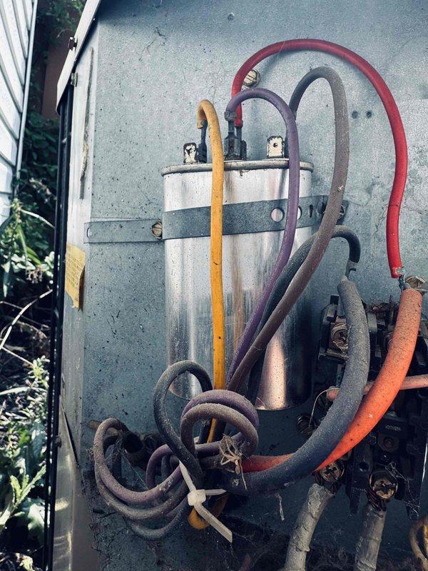 Performed diagnostic assessment of residential HVAC system to address reported uneven temperature distribution throughout multiple zones including basement, upstairs areas, den, and upstairs bathroom. Conducted electrical testing using digital multimeter on outdoor condensing unit components, measuring voltage and capacitance readings to verify proper operation of compressor and fan motor circuits. Inspected outdoor unit capacitor for proper microfarad ratings and electrical connections, noting age-related weathering of unit components and associated refrigerant lines. Evaluated system airflow balance and zoning issues potentially contributing to inconsistent cooling and heating performance across different areas of the home. Diagnostic findings documented for customer review regarding system performance and recommended corrective actions if needed.