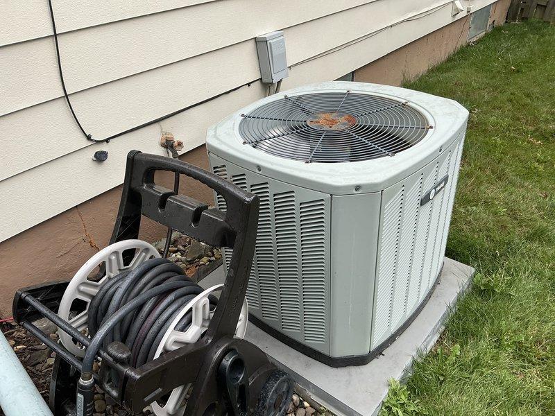 Conducted comprehensive evaluation of 16-year-old residential HVAC system for replacement estimate. Assessed outdoor condenser unit and indoor furnace with humidifier, documenting existing equipment condition and installation configuration. Photographed current system components including outdoor unit on concrete pad and basement-located forced-air furnace to support replacement proposal and equipment specifications.