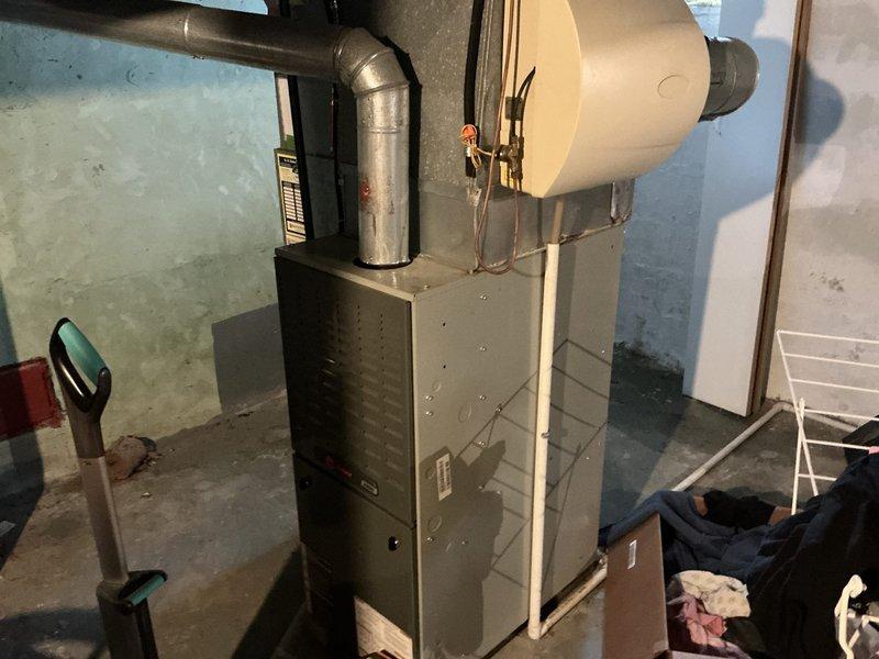Conducted comprehensive evaluation of 16-year-old residential HVAC system for replacement estimate. Assessed outdoor condenser unit and indoor furnace with humidifier, documenting existing equipment condition and installation configuration. Photographed current system components including outdoor unit on concrete pad and basement-located forced-air furnace to support replacement proposal and equipment specifications.
