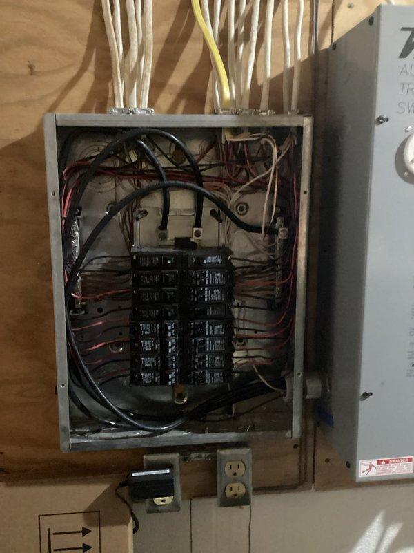 Replaced battery in Winco backup generator system and installed dedicated exterior weatherproof circuit with outlet for trickle charger connection. Wired new circuit from main electrical panel through exterior wall, mounted weatherproof enclosure on siding above brick foundation, and established proper connection to generator charging system to maintain battery health during standby periods.