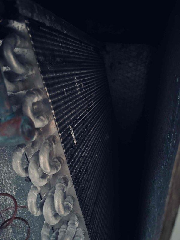 Responded to customer complaint of unit short cycling with 10 seconds runtime followed by 30 seconds off in a repetitive pattern. Inspected system components including heat exchanger coil, refrigerant lines, and associated piping infrastructure. Evaluated PCB and control systems to diagnose intermittent operation issue that was not resolved during previous service visit. Documented equipment condition showing aged copper refrigerant lines and corroded metal pipe assembly with significant oxidation on joints and fittings.
