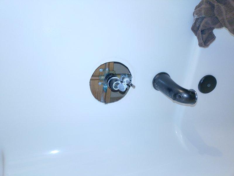 Responded to service call for dripping shower in 1970s-era home. Upon inspection, diagnosed faulty tub spout and shower valve assembly requiring replacement. Disassembled existing drain components and removed deteriorated gaskets and seals. Accessed shower valve through wall opening to evaluate internal plumbing connections and copper supply lines. Replaced worn valve cartridge, installed new tub spout with proper escutcheon plate, and reassembled drain assembly with new gaskets to eliminate leak. Tested system for proper water flow and verified complete cessation of dripping. All components secured and operational upon completion.