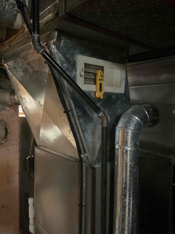Completed MVP cooling maintenance visit on residential HVAC system. Performed standard preventive maintenance inspection of air handling unit and furnace assembly in basement mechanical space. Observed significant condensation present on supply ductwork, indicating proper cooling operation and potential humidity load. Verified electrical disconnect switch operational, inspected ductwork connections, and documented system condition with photos. Unit operating within normal parameters at time of service.