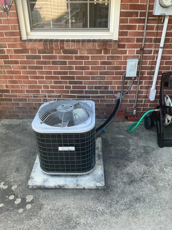 Completed full HVAC system installation including an 80% efficiency furnace and air conditioning system. The indoor Kenmore furnace unit and air handler were installed in the basement utility area with proper metallic supply ductwork connections, PVC condensate drainage lines, and gas piping. The outdoor condensing unit was positioned on a new concrete pad against the brick exterior with appropriate electrical disconnect box, conduit runs, and service clearances for maintenance access.