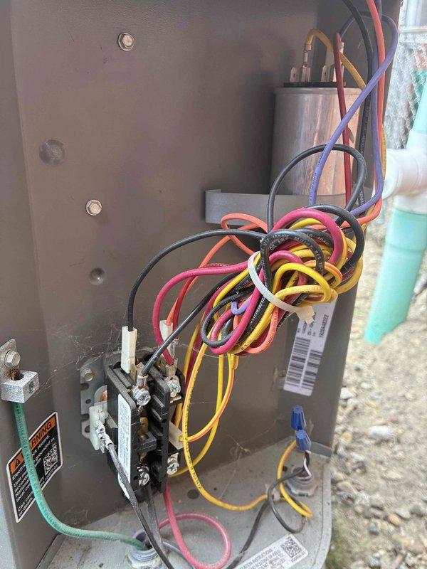 Completed scheduled maintenance visit for 5-year-old Lennox air conditioning system. Inspected outdoor condensing unit, verified proper mounting on concrete pad, and examined electrical disconnect box and associated wiring. Opened control panel to assess internal electrical components including contactor, capacitor, and multi-conductor wiring connections, ensuring all terminals were secure and components functioning within specifications.