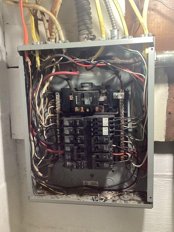 Performed comprehensive electrical inspection of residential main service panel to satisfy insurance policy renewal requirements. Thoroughly examined all interior panel components, circuit breaker connections, wire terminations, and grounding systems. Documented panel configuration showing dual rows of branch circuit breakers with main disconnect, multiple conduit entries with proper connectors, and various conductor routing throughout the enclosure. All circuit breakers, neutral and ground bus bars, and wire connections were visually inspected for proper installation and compliance with electrical code standards. Photographic documentation provided to support insurance inspection requirements.