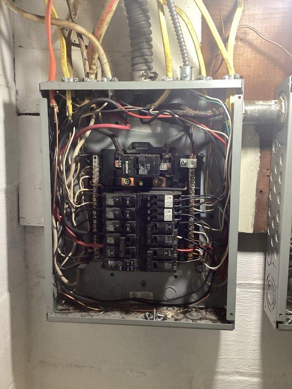 Performed comprehensive electrical inspection of residential main service panel to satisfy insurance policy renewal requirements. Thoroughly examined all interior panel components, circuit breaker connections, wire terminations, and grounding systems. Documented panel configuration showing dual rows of branch circuit breakers with main disconnect, multiple conduit entries with proper connectors, and various conductor routing throughout the enclosure. All circuit breakers, neutral and ground bus bars, and wire connections were visually inspected for proper installation and compliance with electrical code standards. Photographic documentation provided to support insurance inspection requirements.