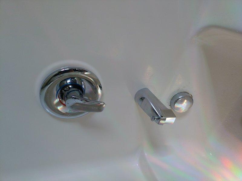 Replaced existing shower valve with new Moen Chateau chrome-finished shower valve, including all associated copper piping accessible through access panel. Installation included new shower arm, tub spout, and complete trim kit with chrome escutcheon plates and lever handle controls. All copper connections were properly soldered and tested for leaks to ensure full functionality of the shower system.