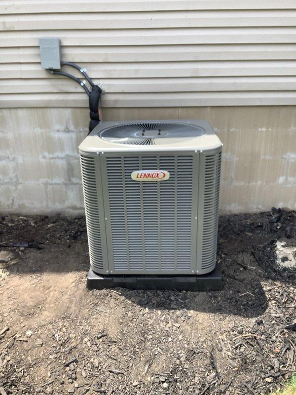 Completed installation of new Lennox air conditioning system including outdoor condenser unit and indoor evaporator coil. Outdoor condenser unit was positioned on composite pad against exterior wall with proper electrical disconnect and conduit connections to meet code requirements. Indoor evaporator coil was installed and integrated with existing Lennox furnace in basement utility area, with all necessary ductwork connections, condensate drain line, and refrigerant lines properly secured and tested for system operation.