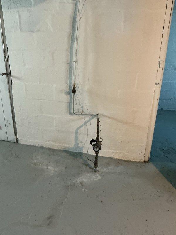 Snaked main drain line through first floor access point to the flange after toilet removal by property owner. Cleared blockage and restored proper drainage flow. Documented pre-existing conditions showing debris accumulation around floor drain and basement utility area.