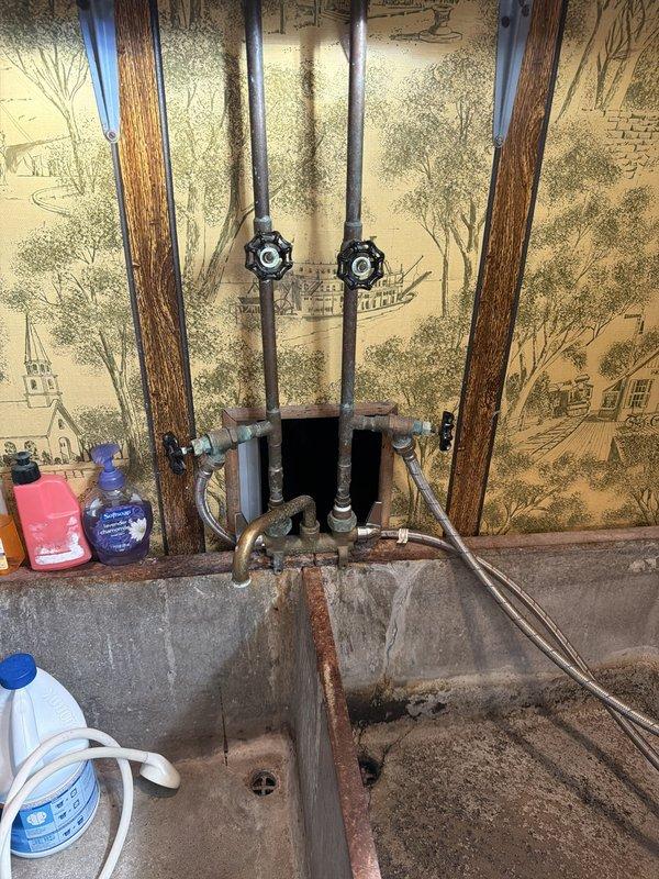 Responded to service call for plumbing and gas line work. Assessed corroded water supply lines at utility sink location and capped off existing gas line to accommodate conversion from gas to electric dryer. Inspected aged plumbing infrastructure including shut-off valves, supply manifold, and copper piping connections. Completed gas line termination per code requirements to ensure safe installation of new electric appliance.