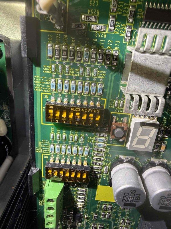 Performed comprehensive air conditioning system inspection on residential HVAC unit estimated to be less than 10 years old. Accessed basement-located equipment consisting of furnace and air handler system with properly installed PVC condensate drainage lines. Inspected control board circuitry, verifying DIP switch configurations and examining all electronic components including capacitors, terminals, and connection points. All system components found to be in proper working condition with no immediate service needs identified. Unit confirmed operational and ready for continued use.