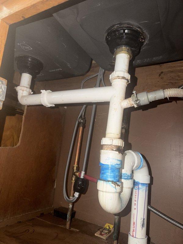 Responded to service call for kitchen sink leak underneath cabinet and replacement of two bathroom sink faucets with matching double-handle fixtures. Inspected kitchen sink plumbing assembly, identified source of leak in drainage system, and performed necessary repairs to P-trap configuration and drain connections. Replaced both existing bathroom vanity faucets with new brushed nickel double-handle units to match customer's aesthetic preference, ensuring proper installation of supply lines and drain assemblies. Tested all fixtures for proper operation and verified no leaks present upon completion.