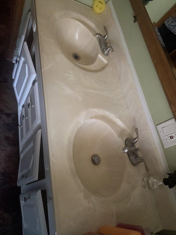 Responded to service call for kitchen sink leak underneath cabinet and replacement of two bathroom sink faucets with matching double-handle fixtures. Inspected kitchen sink plumbing assembly, identified source of leak in drainage system, and performed necessary repairs to P-trap configuration and drain connections. Replaced both existing bathroom vanity faucets with new brushed nickel double-handle units to match customer's aesthetic preference, ensuring proper installation of supply lines and drain assemblies. Tested all fixtures for proper operation and verified no leaks present upon completion.
