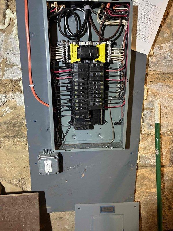 Completed AC circuit installation and panel wiring integration for HVAC system. Installed new circuit breaker in electrical panel with proper wire routing and connections, verified 242V reading at outdoor disconnect serving Frigidaire unit. All connections torqued to specification, panel dressed neatly with organized wire management, and system tested for proper operation.