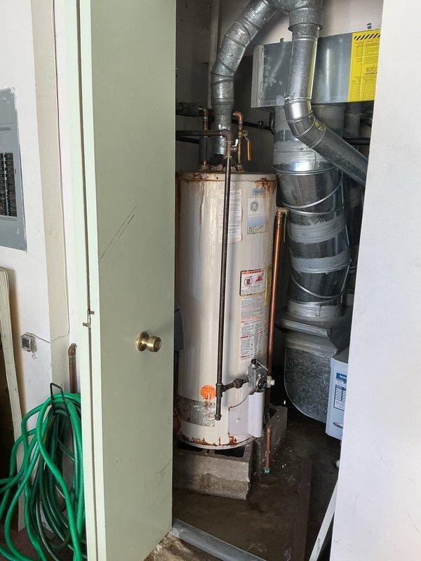 Replaced a non-functional tanked water heater that exhibited severe rust deterioration and corrosion throughout the unit, particularly concentrated at the base and lower third of the tank. Disconnected existing copper supply lines and vent ductwork, removed the failed unit, and installed a new water heater with proper code-compliant connections including hot and cold water lines, temperature and pressure relief valve, and gas supply connections. Tested all connections for leaks and verified proper operation of the new system.