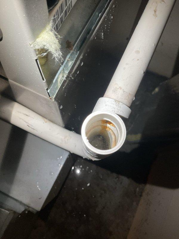 Responded to water leak complaint in basement originating from recently installed furnace. Upon inspection, discovered improperly sealed PVC condensate drain connections with visible moisture accumulation throughout the system enclosure. Resealed threaded PVC pipe connections showing mineral buildup and corrosion, verified proper drainage flow, and confirmed all condensate lines were secure to prevent further water discharge into the basement area.