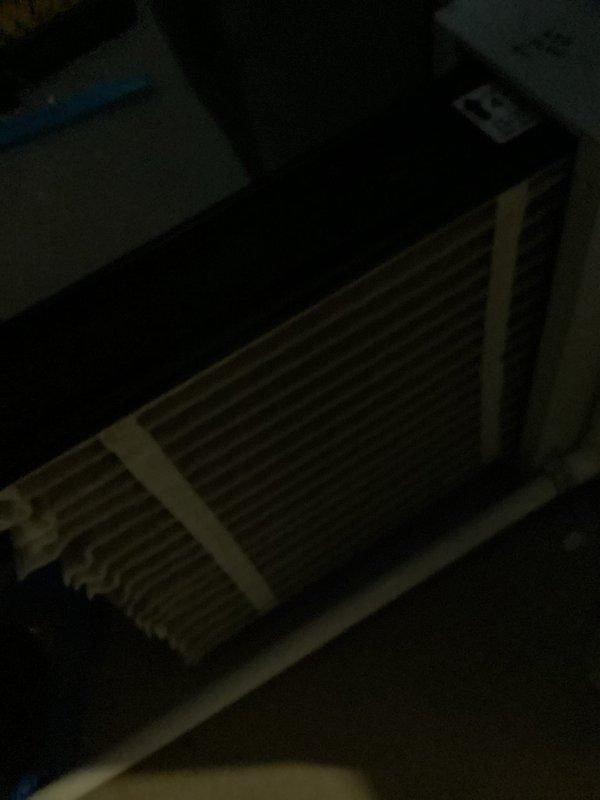 Performed routine maintenance inspection on 8-year-old air conditioning system for MVP customer. Evaluated system components including heat exchanger and recorded ambient temperature reading of 53°F in attic space. Documented equipment condition through photographic records showing HVAC unit with secured banding and temperature measurements on weathered decking, confirming system operational status.