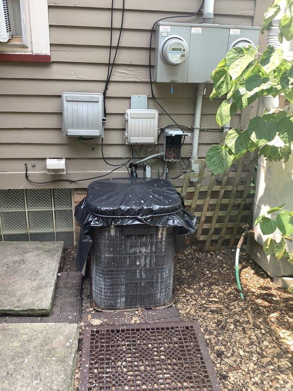 Completed on-site assessment of 23-year-old Amana furnace and air conditioning system serving a duplex upper suite totaling approximately 1,750 square feet across second and third floors. Evaluated existing 70,000 BTU horizontal furnace installation located on third floor and exterior condensing unit to determine replacement specifications. Documented current system configuration through photographic documentation of indoor furnace equipment and outdoor AC condenser with associated electrical components and meter connections to provide accurate replacement estimate for same or slightly larger capacity HVAC system.