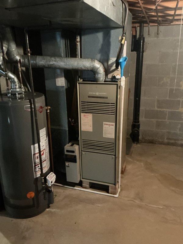 # HVAC System Installation

Completed full HVAC system installation including 80% efficiency furnace and air conditioning condensing unit. Installed new beige furnace unit in basement mechanical room with proper venting and ductwork connections. Mounted outdoor AC condensing unit on concrete pad against exterior brick wall with appropriate refrigerant line routing and electrical conduit. Verified all electrical connections, tested system operation, and confirmed proper airflow and cooling performance. System commissioned and left in full operational condition.
