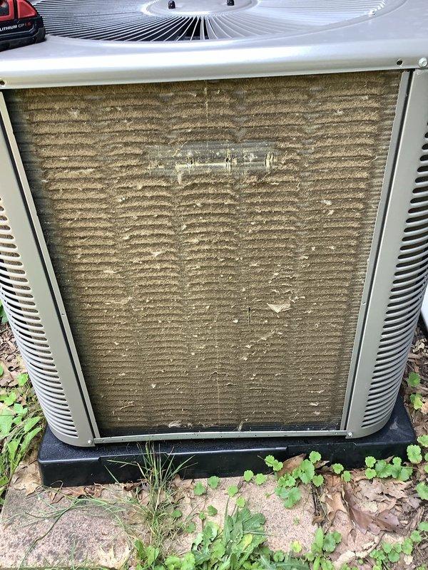 Responded to service call for furnace displaying 4 red blinks followed by 2 blinks error code and condensation issues on AC unit and ductwork. Upon inspection, found outdoor condenser unit with heavily soiled coil fins showing significant dirt, pollen, and environmental debris accumulation with greenish discoloration. Air filter on unit exhibited extreme clogging with brownish-gray particulate matter throughout pleated sections, severely restricting airflow. Diagnosed condensation on ductwork as result of inadequate airflow causing temperature differential and moisture accumulation. Documented equipment condition through photographs showing Trane condenser unit requiring cleaning and maintenance. Recommended immediate coil cleaning, filter replacement, and airflow restoration to resolve error codes and eliminate condensation problems affecting system performance.