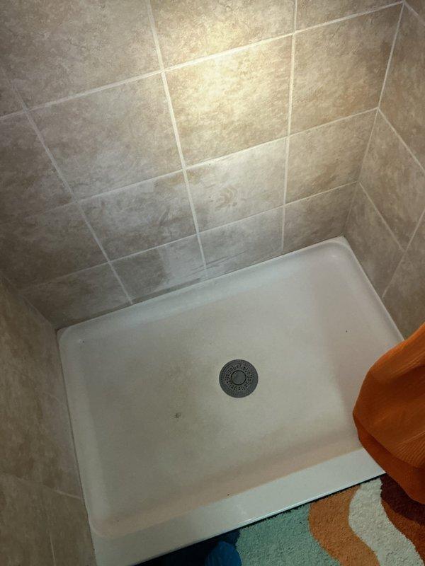 Responded to emergency call for blocked drain causing water infiltration through flooring in 49-year-old residential property. Upon arrival, conducted comprehensive assessment of plumbing system to identify source of blockage and water damage. Inspected ceiling area revealing water staining and potential structural concerns from drainage backup. 

Performed drain clearing procedures using professional-grade equipment to remove obstruction from main drainage line. Verified proper water flow and drainage functionality in shower stall and connected fixtures. Tested system under normal operating conditions to ensure blockage was completely eliminated and no residual flow restrictions remained.

Confirmed all drainage systems returned to normal operation with no further water seepage or backup occurring. Documented conditions with photographic evidence showing affected ceiling area and cleared shower drain system for customer records.