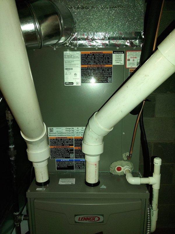 Completed installation of Lennox ML13KC1-036-230A03 air conditioning system with matching evaporator coil in interior mechanical room. Unit was charged with R-454B refrigerant per factory specifications at 6 lbs 4 oz total charge weight. Installed condensate drain lines using white PVC piping with proper pitch and termination, verified all electrical connections at 208/230V single-phase service, and secured all ductwork connections with foil tape. System was tested for proper operation and all manufacturer labels remain visible for future service reference.