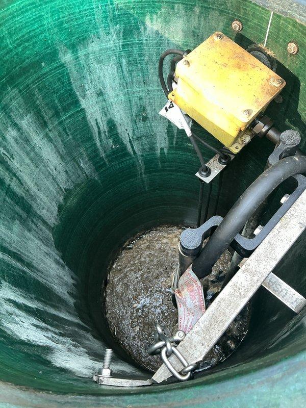 Responded to service call for malfunctioning grinder pump system requiring complete replacement. Upon arrival, inspected existing pump station and confirmed grinder pump failure. Removed old yellow pump unit from fiberglass wet well, which showed significant wear, sediment accumulation, and operational deterioration. Extracted pump assembly including mounting hardware, electrical connections, and discharge piping. Cleaned debris and sediment from bottom of station to ensure proper installation of replacement unit. Installed new grinder pump with appropriate mounting brackets, connected electrical wiring per manufacturer specifications, and verified all plumbing connections were secure. Tested system operation to confirm proper grinding function and discharge performance before restoring station to service.