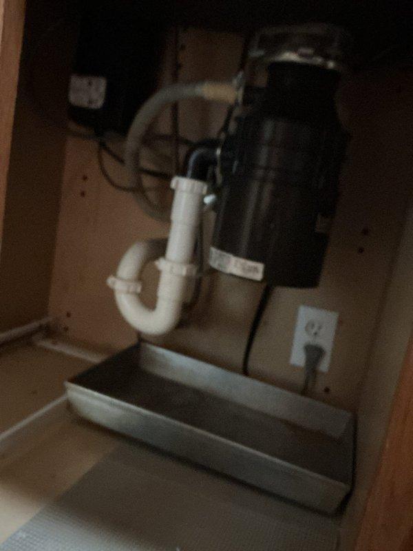 Responded to service call for garbage disposal replacement estimate and slow-draining bathroom vanity sink. Upon arrival, conducted thorough inspection of kitchen sink plumbing system and photographed existing garbage disposal unit and drain assembly configuration. Assessed current disposal mounting hardware, electrical connections, and drain line connections to determine replacement requirements and compatibility with existing plumbing infrastructure.

Examined bathroom vanity sink drain system and identified slow drainage issue. Inspected P-trap assembly, drain tailpiece, and connecting PVC pipes for potential blockages or improper venting. Documented under-sink plumbing configuration including white PVC drain components, flexible corrugated drain hose connections, and existing trap assembly. Verified electrical outlet accessibility within cabinet space for disposal installation requirements.

Provided customer with comprehensive estimate for garbage disposal replacement including re