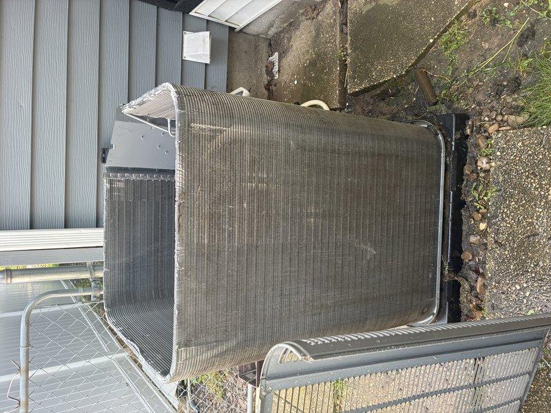 Completed MVP recurring cooling maintenance visit on outdoor air conditioning condenser unit. Performed thorough inspection of heat exchanger coil, noting visible cleaning patterns on finned surfaces, and documented current condition of compressor motor, electrical connections, and mounting components. Unit showed normal weathering consistent with outdoor installation; photographed equipment condition and surrounding area for maintenance records.