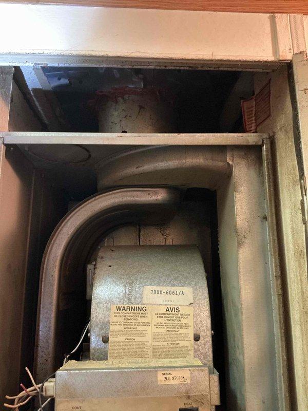 Completed HVAC system replacement estimate for a mobile home with a 30-year-old furnace unit showing significant age and wear. The existing system, housed in a confined mechanical closet with deteriorated ductwork and accumulated dust throughout all components, was assessed for full replacement due to obsolescence and safety concerns related to aged gas valve assembly, worn electrical connections, and compromised ventilation infrastructure.