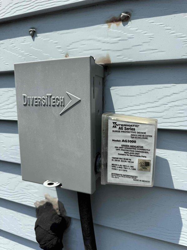 Completed MVP Cooling Visit performing routine maintenance inspection on outdoor HVAC unit. Inspected electrical components including capacitor and wiring connections within the unit compartment, documented equipment condition with exterior surge protection device and DiversiTech electrical box installation showing normal wear patterns consistent with outdoor exposure.