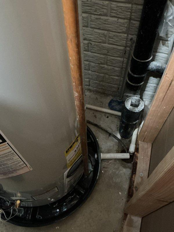 Replaced a leaking 50-gallon Bradford White water heater with a new 50-gallon Bradford White unit featuring a 6-year manufacturer warranty. Removed the existing saddle valve and installed a new tee fitting with an approved shut-off valve to meet current plumbing code requirements. Reused the existing expansion tank, which was less than a year old and in good working condition. Installed a new molded plastic drain pan with discharge line routed to the floor drain for proper leak protection. Verified the main water shut-off valve was operational and retained it for continued use.