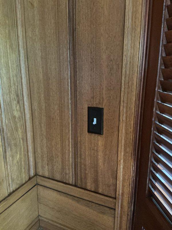Responded to outlet issues in an 85-year-old residential property. Inspected and serviced electrical junction box with visible terminal connections, replaced defective switch mechanism with illuminated toggle switch in wood-paneled room, and verified proper functionality of all affected circuits and outlets throughout the home.