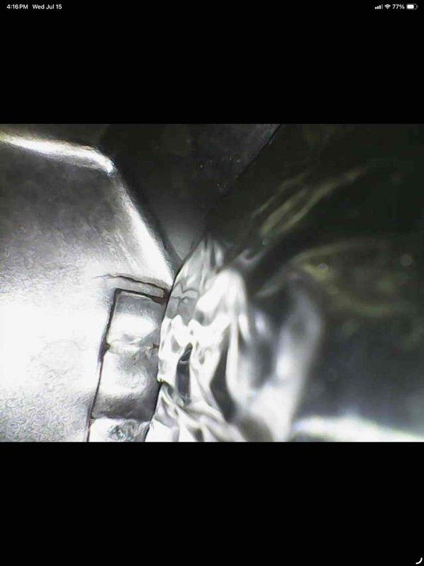 Responded to customer complaint of high humidity and inadequate cooling. Upon inspection, found extensive frost and ice buildup on supply grille and evaporator coil assembly, indicating restricted airflow or low refrigerant charge causing coil to freeze. Documented frozen conditions with photos showing severe ice accumulation on ventilation components and visible moisture on ductwork connections in mechanical space.