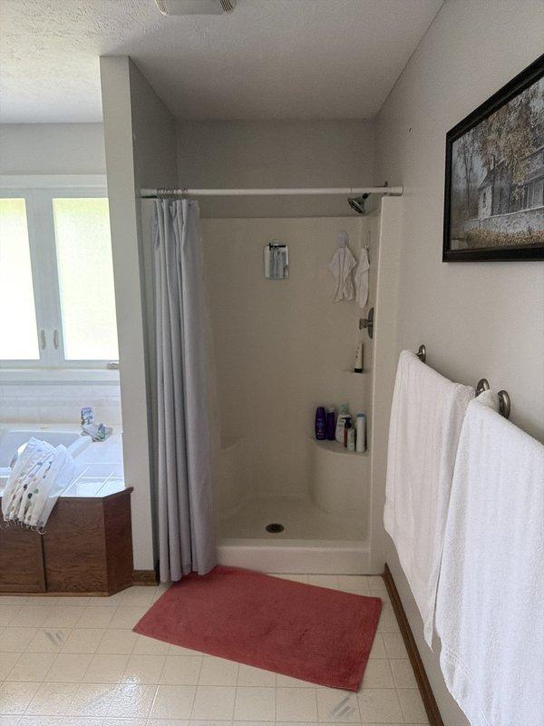 Completed full shower replacement including removal of existing fixtures and installation of new 32x60 Sterling Kohler shower base and surround system. Installed new single-handle shower valve with chrome trim and Moen Magnetix handheld showerhead with flexible metal hose. Connected new shower assembly to existing 1-1/2 inch drain line, ensuring proper pitch and watertight seal. Mounted three integrated corner shelving units within the surround for storage accessibility. All plumbing connections tested and verified for proper operation and no leaks. Work completed with one helper over full-day installation.