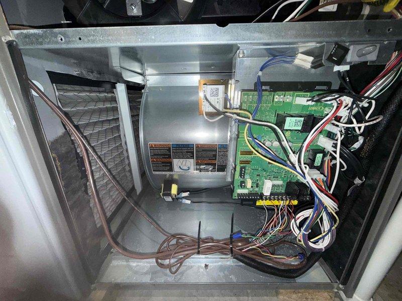 # HVAC Maintenance - Cooling Service Completed

Performed comprehensive MVP cooling maintenance visit on residential HVAC system. Conducted thorough inspection of all interior components including blower assembly, control module, and multiple circuit boards. Verified proper electrical connections throughout the system, inspecting multicolored wiring harnesses and terminal blocks for secure connections and signs of wear.

Examined the control panel enclosure and capacitor for proper operation. Cleaned accumulated dust and debris from the base of the unit and interior compartments. Performed leak check on refrigerant system per customer request, focusing on area that was previously repaired last year. All connections, coils, and refrigerant lines inspected for signs of leakage. System found to be operating within normal parameters with no active leaks detected. Unit tested and confirmed to be functioning properly upon completion of maintenance visit.