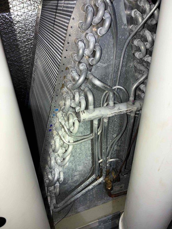 Completed scheduled BS-MVP cooling maintenance visit on 4-year-old Lennox HVAC system. Upon inspection, discovered significant frost accumulation on evaporator coil assembly, indicating potential refrigerant flow restriction or airflow issues. Documented system condition with photos showing crystalline ice buildup across serpentine coil tubing and confirmed all refrigerant lines, brass fittings, and connections for proper operation. Verified furnace and air handler installation integrity, inspected copper refrigerant lines, condensate drain system, and all electrical connections. System components properly mounted with adequate service clearance maintained.