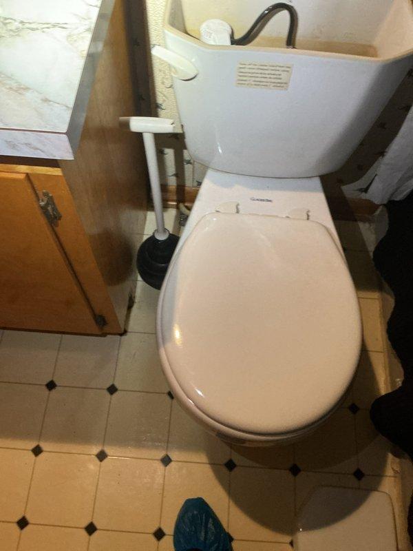 Responded to service call for clogged toilet on first floor. Upon arrival, assessed the fixture and surrounding area, documenting existing conditions including mineral deposits and staining on the bowl and seat rim. Successfully cleared the blockage and restored proper drainage and flushing function. Verified toilet operation and left fixture in working order with plunger available for homeowner use.