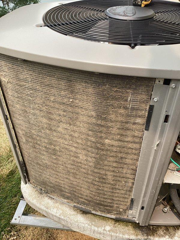 Completed MVP cooling maintenance visit on 7-year-old Lennox system that had been rescheduled from previous appointment. Upon inspection, found outdoor condensing unit coils heavily contaminated with dirt, dust, and debris buildup significantly restricting airflow through aluminum fins. Performed thorough coil cleaning to restore proper heat transfer efficiency and system performance. Documented equipment condition with photos of indoor furnace unit and outdoor condenser before service completion.