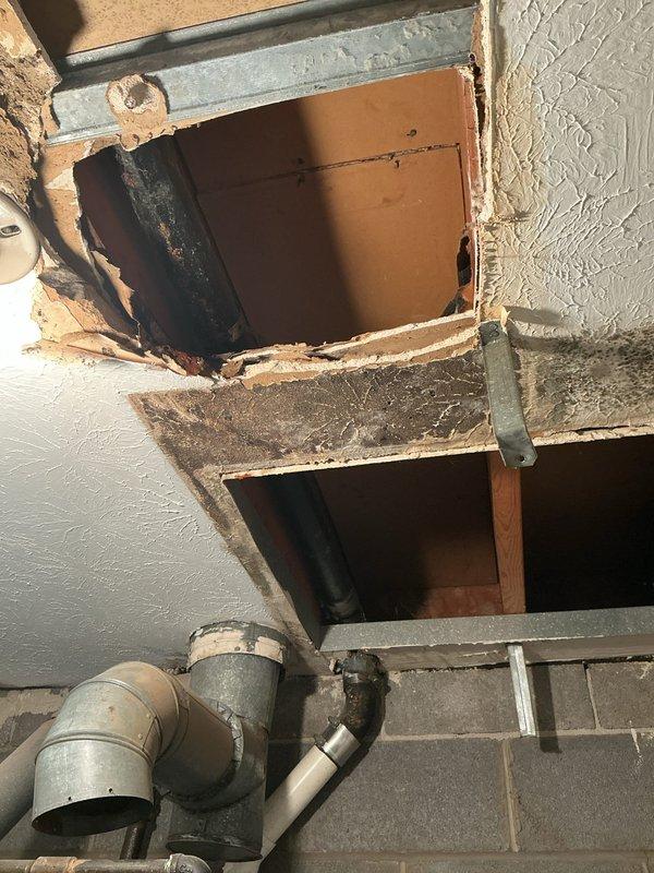 Opened drywall ceiling to access and replace deteriorated cast iron double lavatory drain line, installing new drainage piping from fixtures down through ceiling cavity. Replaced drain traps at both lavatory sinks and opened master bathroom wall adjacent to sink and neighboring bath cabinet for complete drain replacement. All compromised cast iron piping successfully eliminated and replaced with new drainage system.