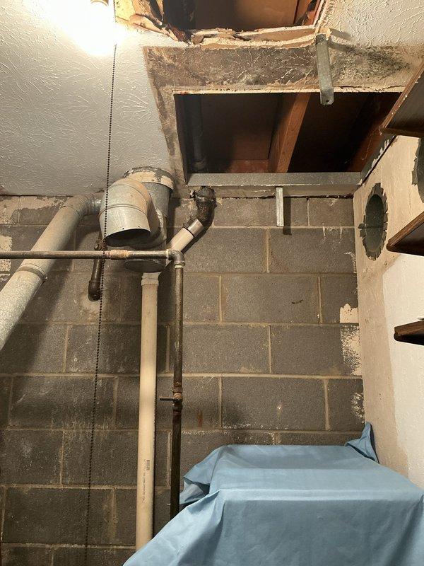 Opened drywall ceiling to access and replace deteriorated cast iron double lavatory drain line, installing new drainage piping from fixtures down through ceiling cavity. Replaced drain traps at both lavatory sinks and opened master bathroom wall adjacent to sink and neighboring bath cabinet for complete drain replacement. All compromised cast iron piping successfully eliminated and replaced with new drainage system.